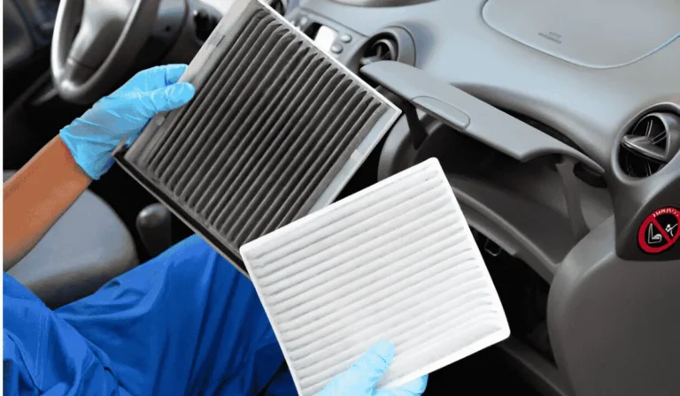 A mechanic replacing a dirty cabin air filter inside a car