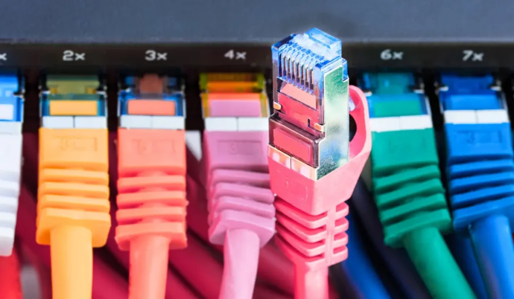 Close-up of an Ethernet cable plugged into a router, showing a fast and stable gaming and streaming setup.
